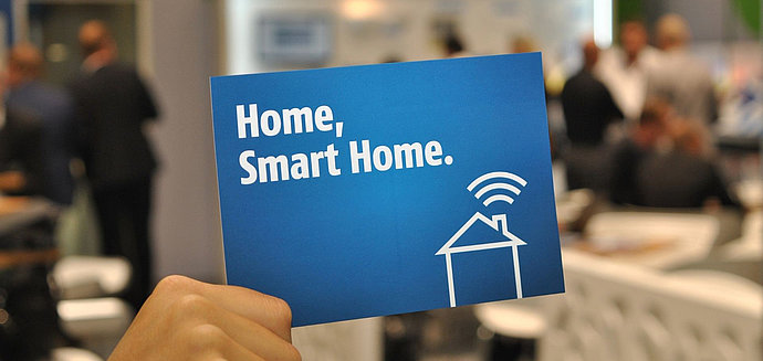 Hand hält eine Karte mit der Auschrift Smart Home